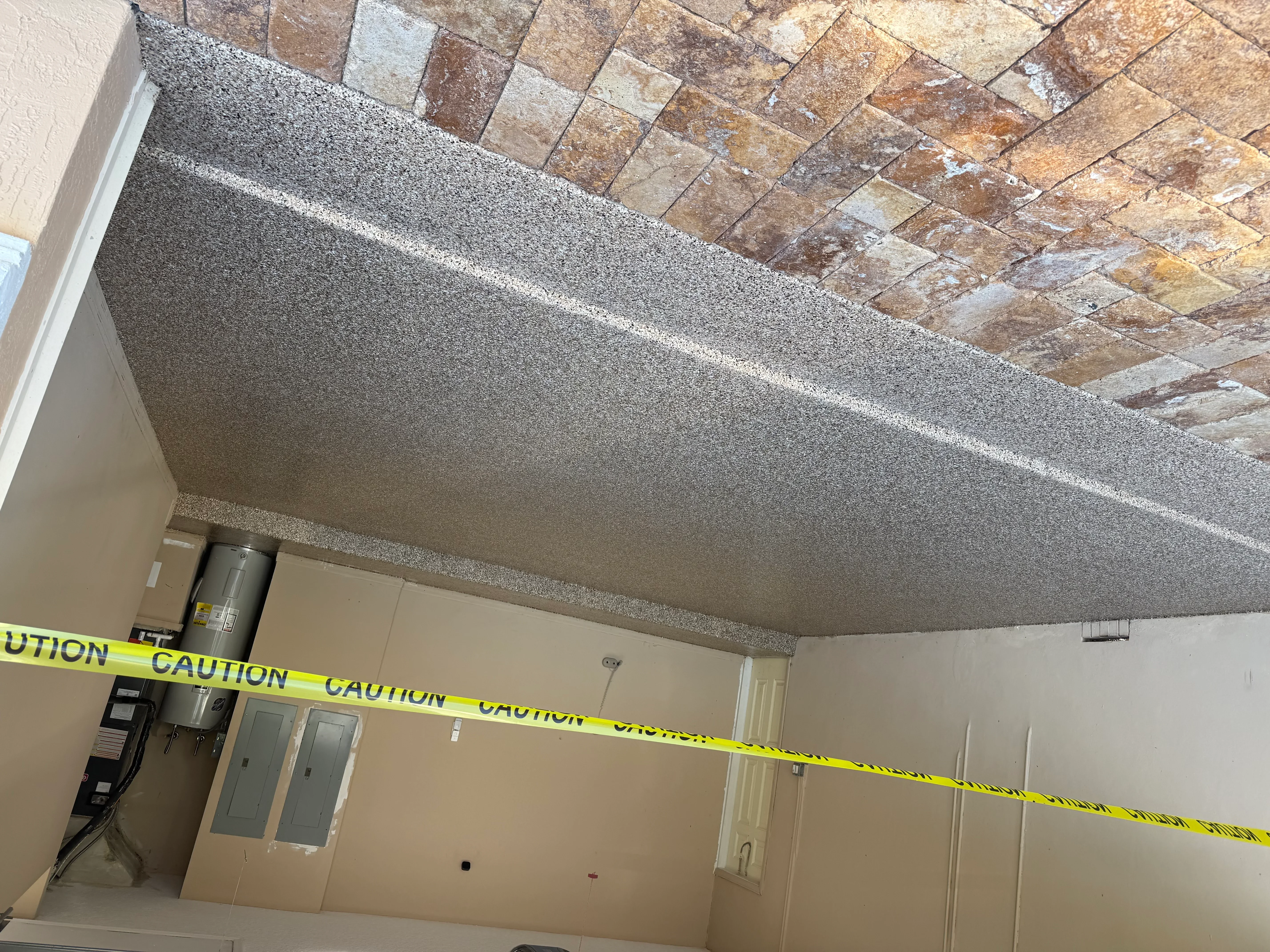 Gray textured concrete ceiling with clean edges against drywall and brick soffit